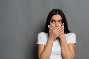 Woman placing her hands on mouth