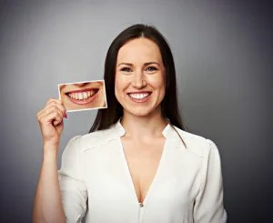 women smiling with a photograph in her hand