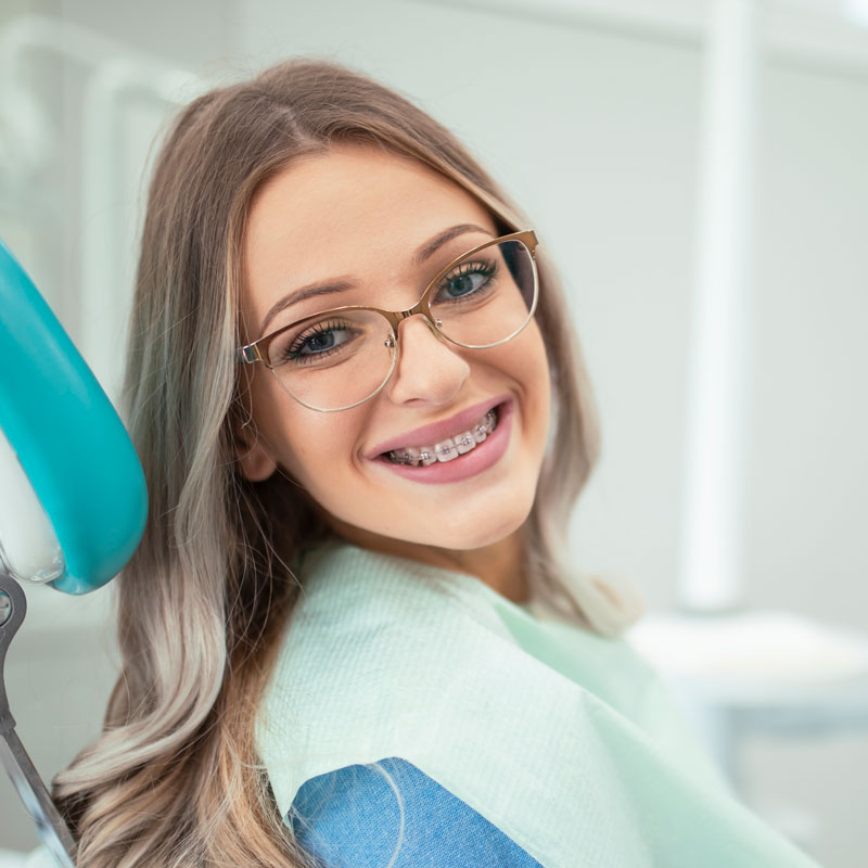 Woman with braces in dentist chair before exam